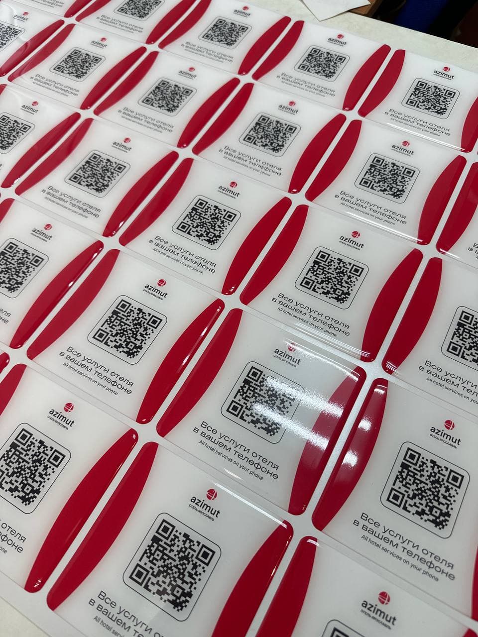 Лист 3D-наклеек с QR-кодами после заливки эпоксидной смолой на производстве в Казани